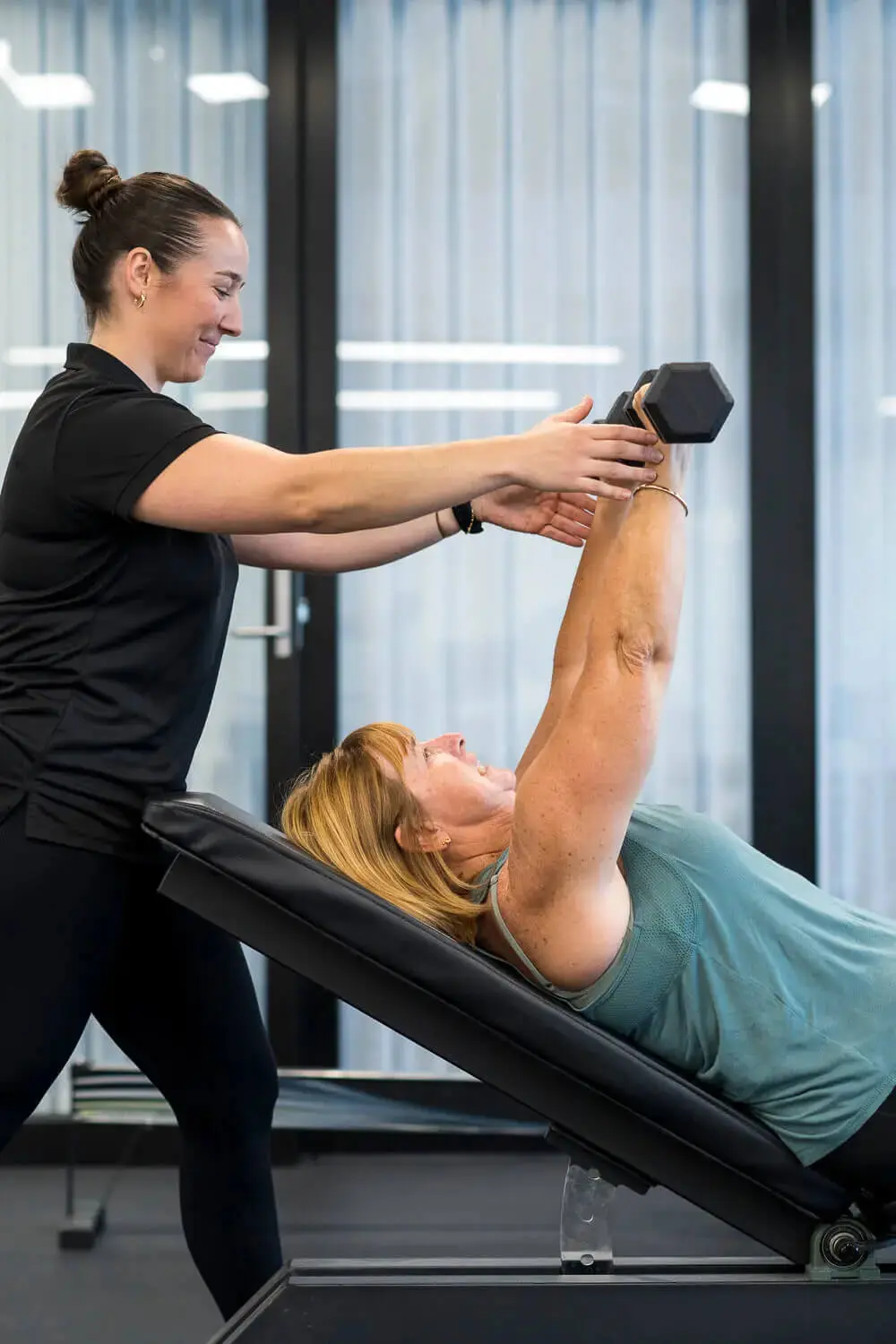 Individual working with an exercise physiologist during rehabilitation training.
